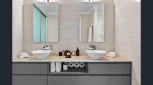 a bathroom with two sinks and two mirrors at Exclusive Isolated Getaway Mowbray Port Douglas in Mowbray
