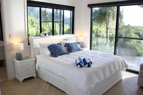 a bedroom with a large white bed with blue pillows at Exclusive Isolated Getaway Mowbray Port Douglas in Mowbray