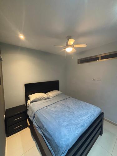 Un dormitorio con una cama y un ventilador de techo. en Surf VIP location, en Cóbano
