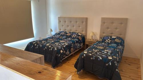 a bedroom with two beds and a table and a mirror at Duplex en villa el chocon LO DE CARLITOS in Villa El Chocón