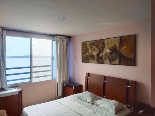 a bedroom with a bed and a large window at Apartamento cerca Bocagrande in Cartagena de Indias