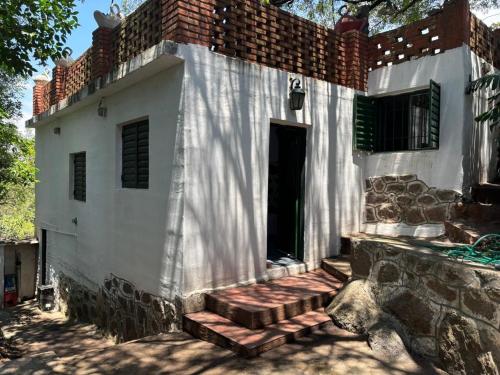 a white building with a staircase in front of it at Refugio Blue Hill in Villa Cerro Azul
