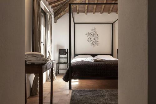 1 dormitorio con cama con dosel y mesa en Historic Apartment With San Gimignano Hills View, en Villa del Monte