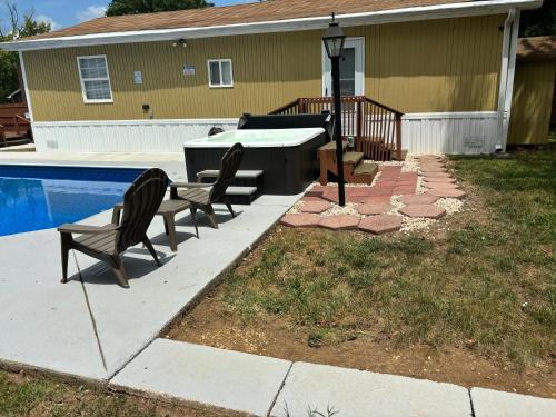 um quintal com uma piscina e duas cadeiras e uma mesa em Luxurious Pool and Spa Home with optional Studio Apts em Durham