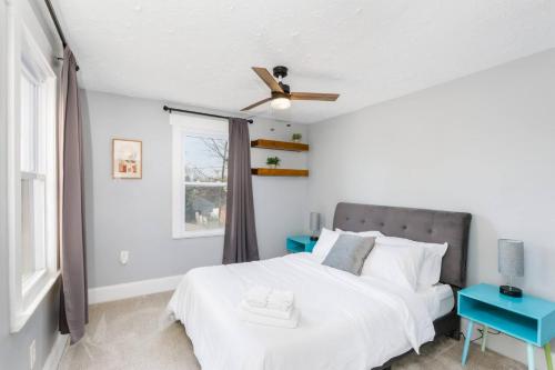 ein weißes Schlafzimmer mit einem Bett und einem Fenster in der Unterkunft Modern 3BR w Yard Garage in Columbus