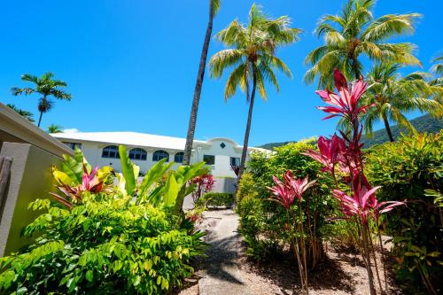 a view of the front of the resort with palm trees at Mango Lagoon Resort & Wellness Spa in Palm Cove