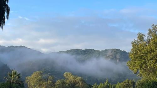 a view of a mountain with clouds in the sky at Hospedaje Los Pavo Reales in Tepoztlán
