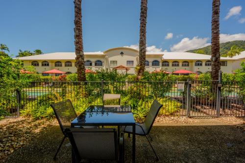 a table and chairs in front of a building at Mango Lagoon Resort & Wellness Spa in Palm Cove