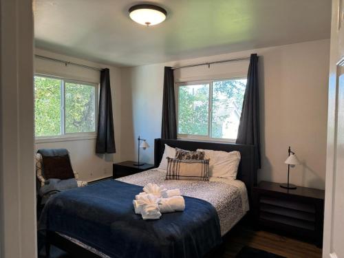 ein Schlafzimmer mit einem Bett und zwei Fenstern in der Unterkunft Midnight Sun - Near Airport and Shopping in Anchorage