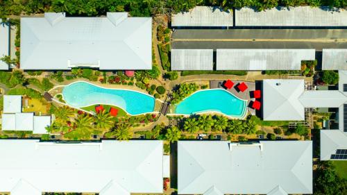 an aerial view of a resort with two swimming pools at Mango Lagoon Resort & Wellness Spa in Palm Cove