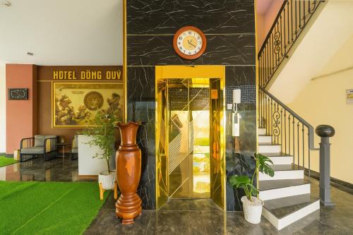 a lobby with stairs and a clock on the wall at Dũng Quyến Homestay in Danang