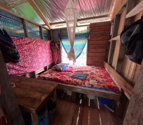 een kleine kamer met een bed en een tafel bij Midemide Island Ecolodge 