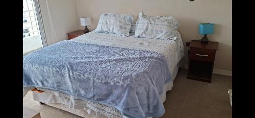 - une chambre avec un lit doté d'une couette et d'oreillers bleus dans l'établissement Depto Puertas del Mar La Serena, à La Serena