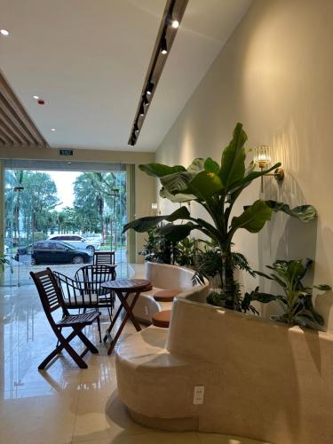 a lobby with a potted plant and tables and chairs at Aura Beachfront Hotel - Apartment in Da Nang