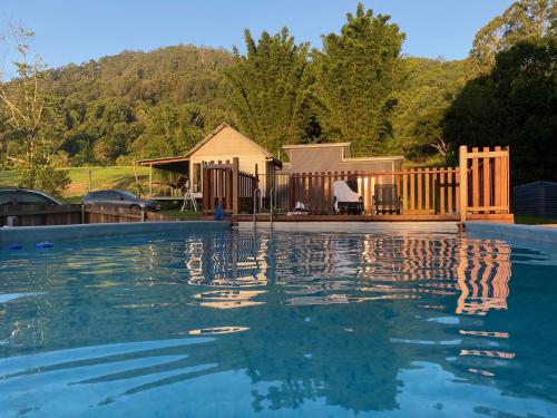 a swimming pool in front of a house at Nimbin waterfall retreat in Nimbin