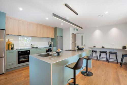a kitchen with a counter and some chairs in it at Deluxe Queen Room at Wolfe Street in Whangarei