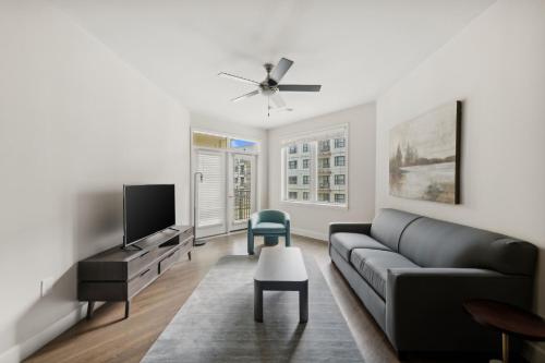 a living room with a couch and a tv at Kasa Village District Raleigh in Raleigh