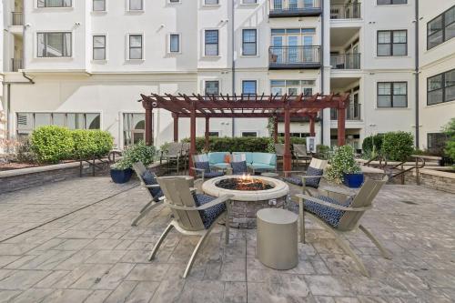 a patio with chairs and a fire pit in front of a building at Kasa Village District Raleigh in Raleigh