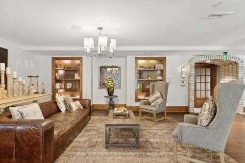 a living room with a brown couch and chairs at Kasa Village District Raleigh in Raleigh