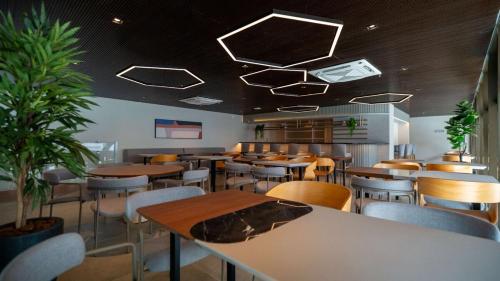 a restaurant with tables and chairs and lights on the ceiling at Studio Fortal in Fortaleza