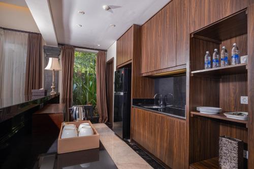 een keuken met houten kasten en een aanrecht met spoelbak bij Homm Saranam Baturiti in Bedugul