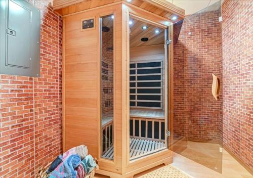 a sauna with a glass door in a brick wall at Lakefront Kayaks, HotTub FirePit Sauna Pool in East Stroudsburg