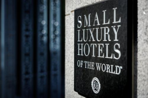 a sign that reads small luxury hotels of the world on a book shelf at Hotel Chourakukan Kyoto Gion 長楽館 京都 in Kyoto