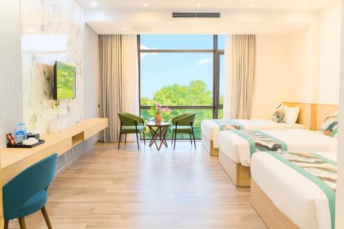 a hotel room with two beds and a table at Sala Home Móng Cái in Móng Cái