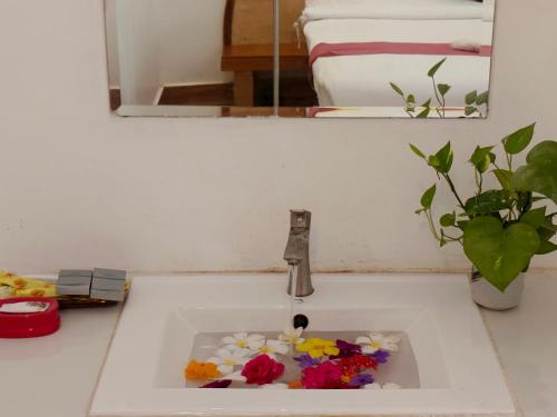a sink with flowers in it in a bathroom at Boreirom TeukChhou lodge By JK6 in Phum Mak Prang