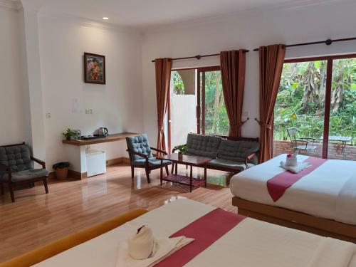 a hotel room with a bed and a table and chairs at Boreirom TeukChhou lodge By JK6 in Phum Mak Prang