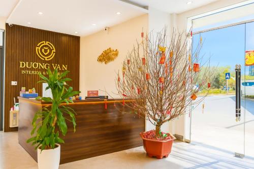 a lobby with two potted trees in front of a duing van entrance at Tường Vân Legend Hotel in Cao Bằng