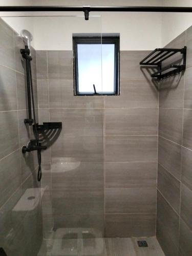 a bathroom with a shower with a window at Lex Place Syokimau in Syokimau