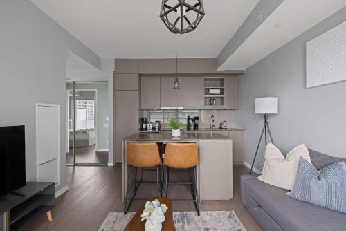 a kitchen and living room with a couch and a table at Chic 1-Bedroom Downtown Toronto Getaway in Toronto