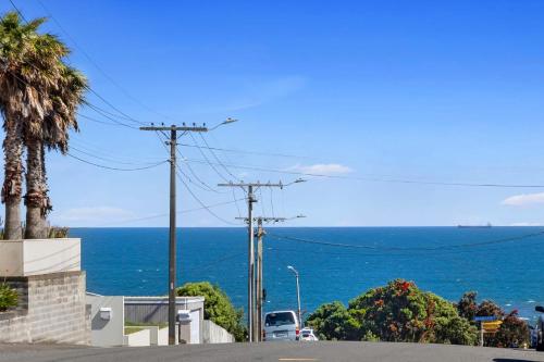 a view of the ocean from a street at Beach Studio - coastal escape near Fitzroy Beach in New Plymouth
