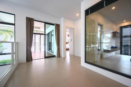un couloir vide avec une grande fenêtre en verre dans une maison dans l'établissement New Luxury Pool Villa Bangtao Free Electricity & Daily Cleaning, à Ban Pak Lak