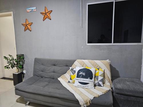 a living room with a gray couch with a blanket at Marques Beach House MCZ in Maceió