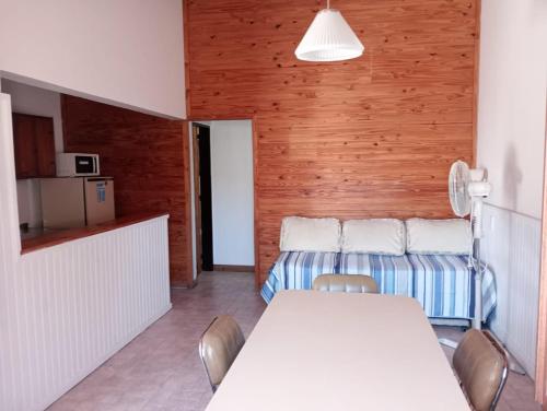 a dining room with a white table and chairs at Ruca Melin in Las Grutas