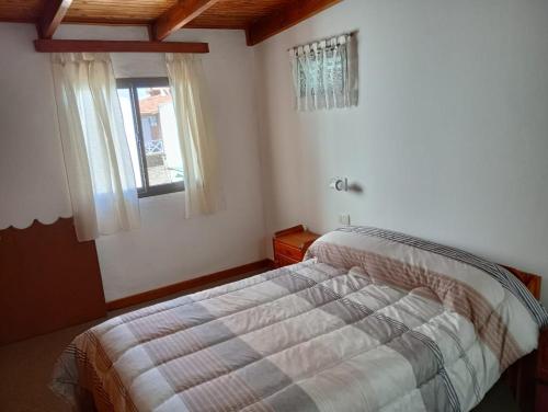 a bedroom with a bed and a window at Ruca Melin in Las Grutas