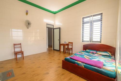 een slaapkamer met een bed, een tafel en stoelen bij Cường Thu Motel Quảng Trị in Xã Thanh Trạch