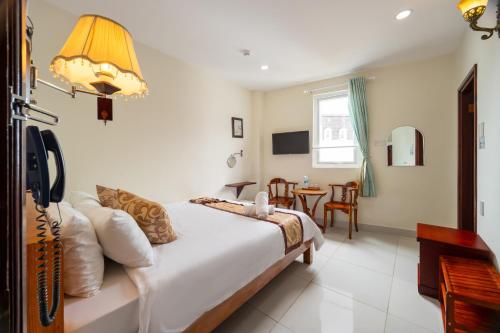 Postel nebo postele na pokoji v ubytování Khách Sạn Đồi Mây Đà Lạt