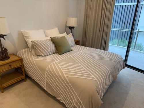 Un dormitorio con una cama grande con ventana. en Hideaway at 10310, en Maroochydore