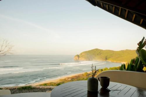 a table with a view of the ocean at Elysian Cove - One Bedroom Villa in Sekongkang Bawa