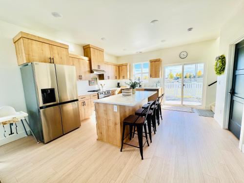 Una cocina con refrigerador y una mesa con sillas. en New 3BR Home w Garage Near BYU-Idaho, en Rexburg
