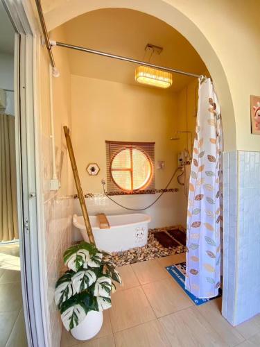 a bathroom with a tub and a toilet and a sink at Zoo Villa บ้านน้องแมว in Nan