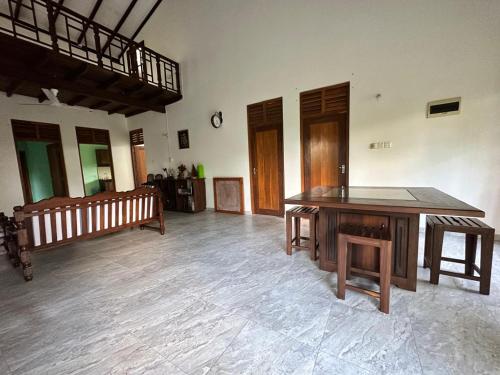 a large room with a wooden table and benches at Calm Casita Luxury Villa in Matara in Matara
