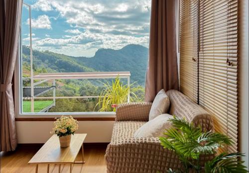 a living room with a couch and a large window at เอวาเเคมป์ ภูชี้ฟ้า Avacamp phuchifa in Ban Seng Choi