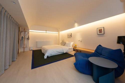 成都市にあるChengdu Kuanzhai Yuntu Serviced Apartmentのベッドと青いソファのある寝室
