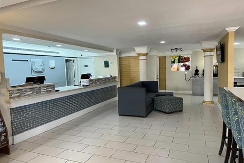 a lobby with a waiting area with a couch and a bar at Baymont by Wyndham Nacogdoches Near University in Nacogdoches