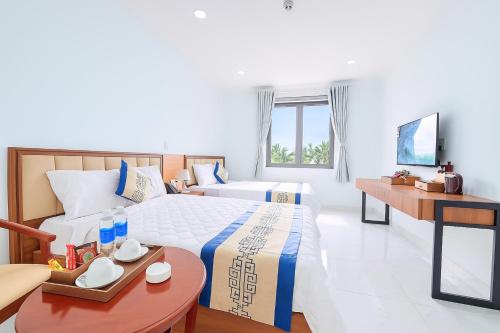 a hotel room with two beds and a table at Điêu Thuyền Hotel Bến Tre in Ben Tre