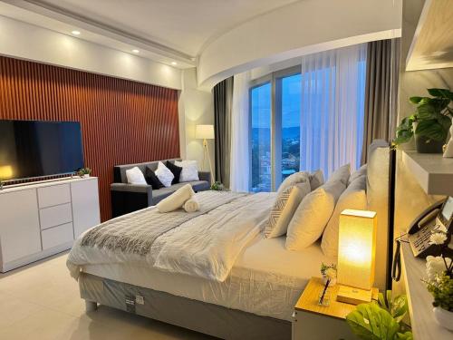 een slaapkamer met een groot bed met een groot raam bij 40 sqm Studio at Aeon Towers in Davao City